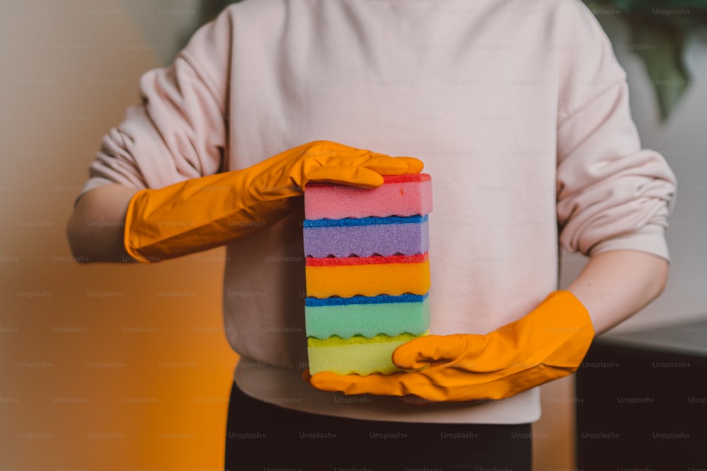 una persona con guantes de goma amarillos sosteniendo un pedazo de pastel