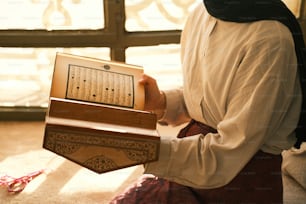 a woman in a white shirt holding a wooden box