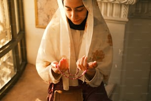 a woman wearing a white veil and holding a box