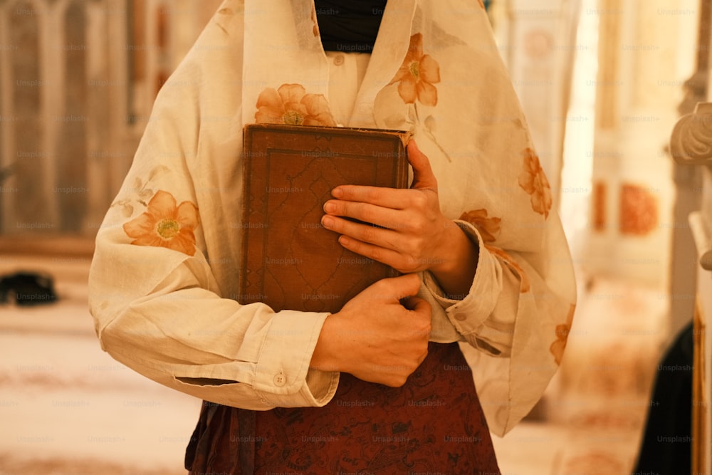 une personne en tenue de prêtre tenant un livre