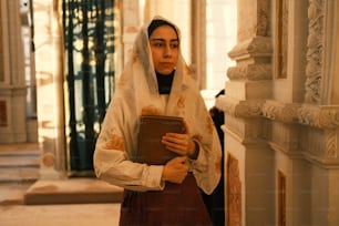 uma mulher em uma roupa de freira segurando um livro