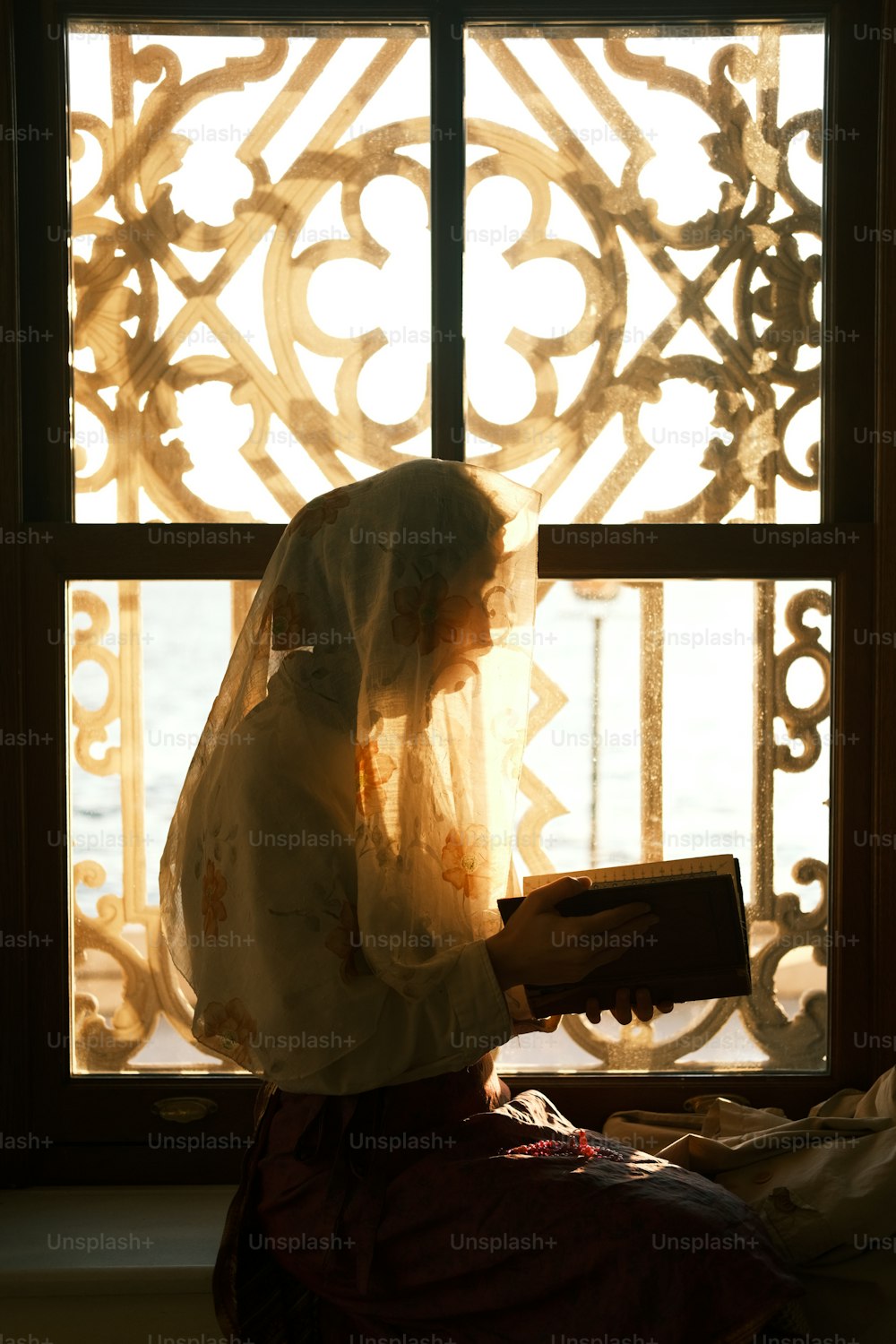 a woman in a veil is looking out a window