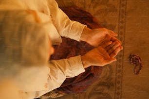 una persona che tiene le mani unite in preghiera
