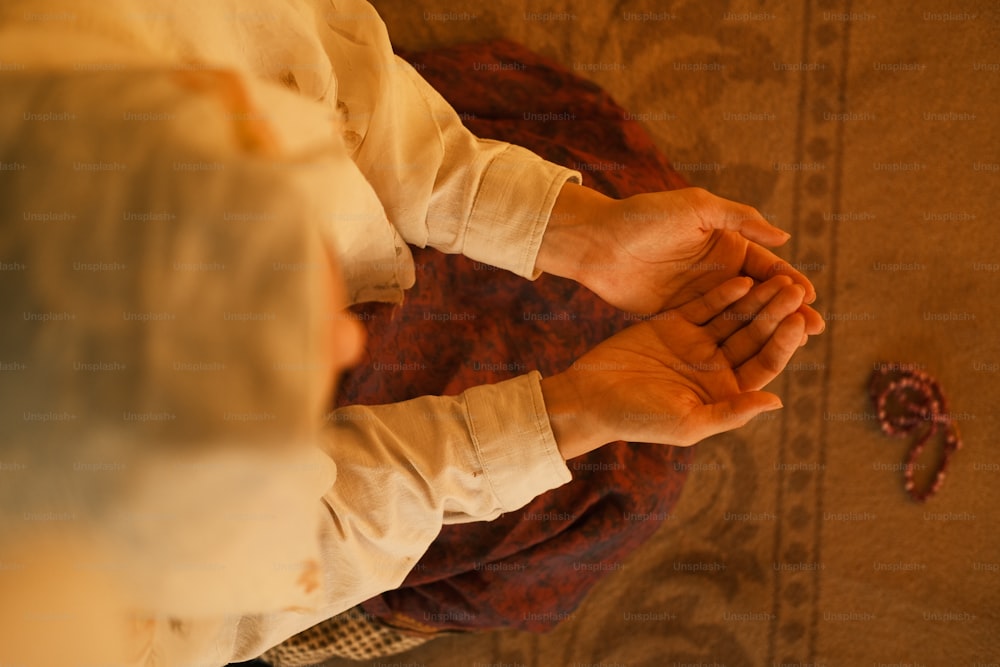 uma pessoa segurando as mãos juntas em oraç�ão