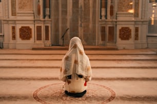 Eine Frau in weißem Schleier sitzt auf dem Boden