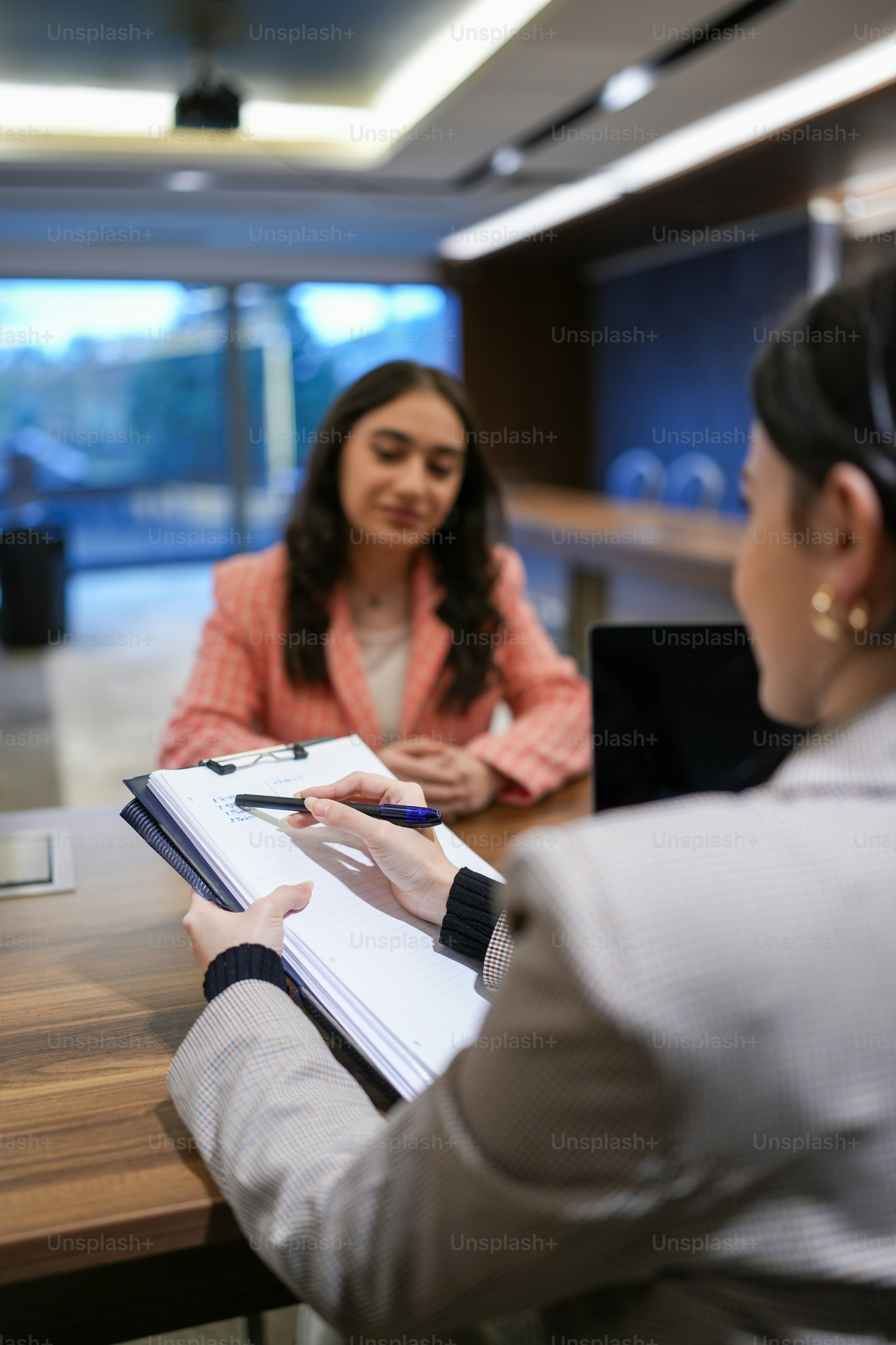 a woman sitting at a table with a notebook in front of her