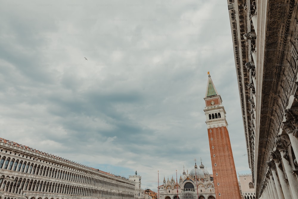 a clock tower towering over a city next to a tall building