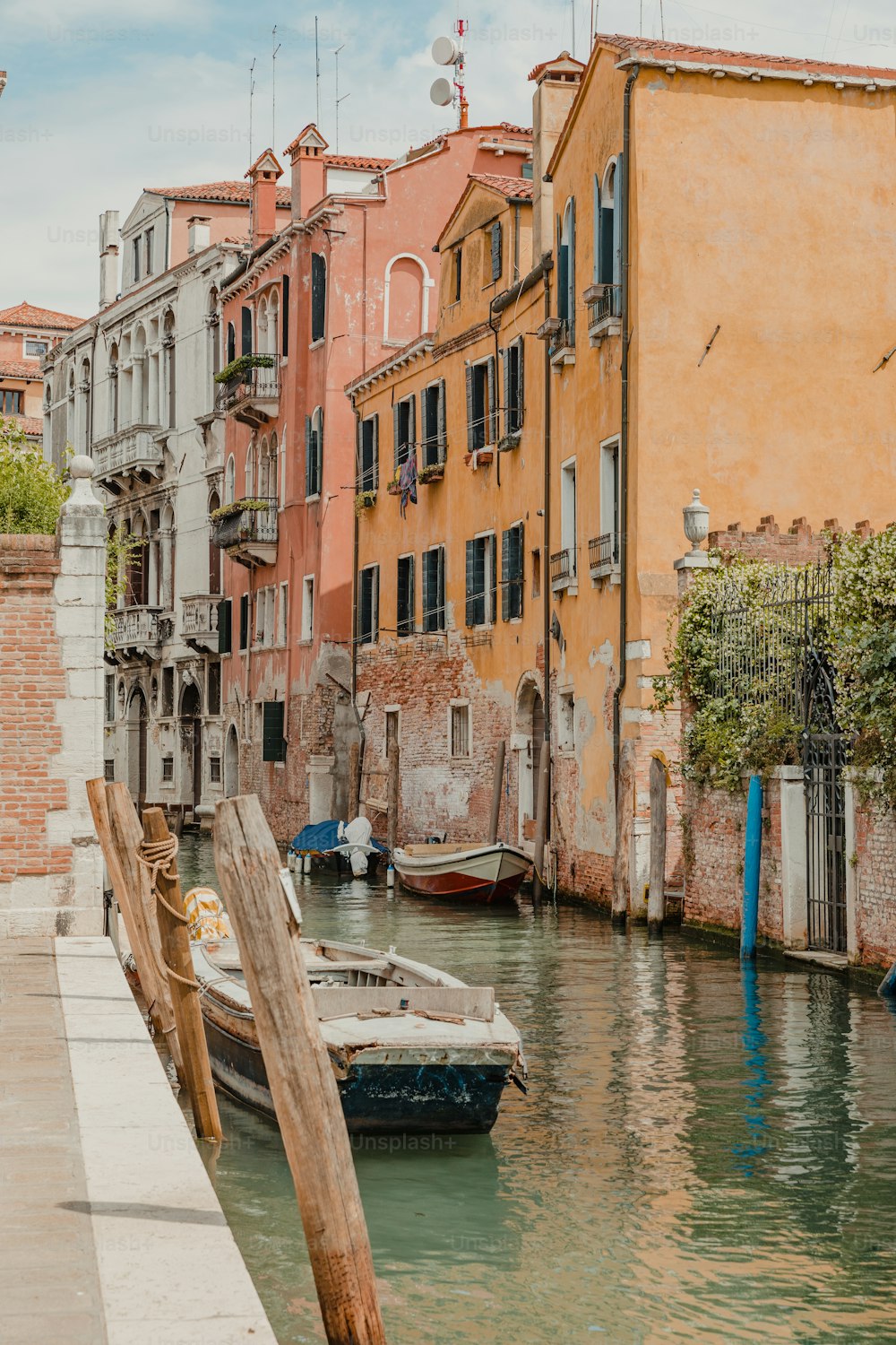 a boat is docked in a canal between buildings