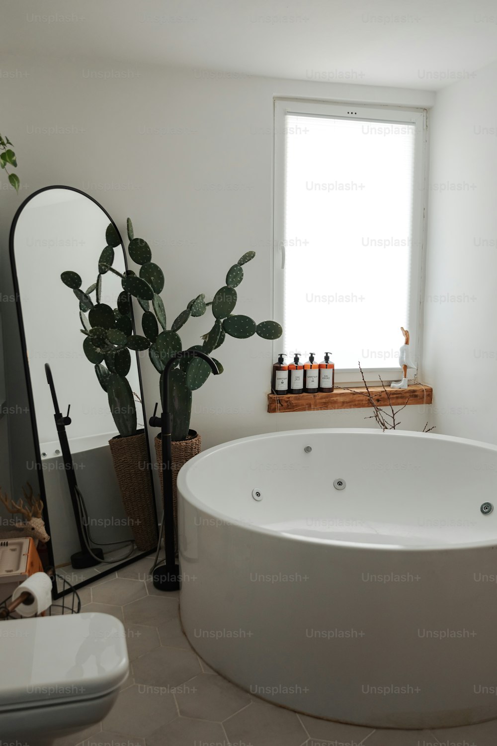 a large white bath tub sitting next to a window