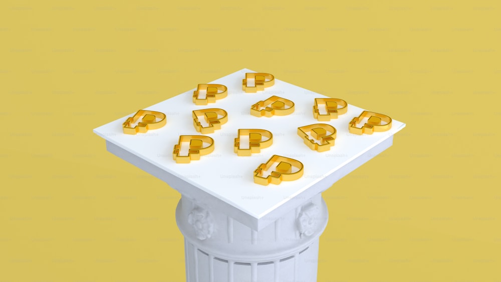 a white table topped with gold letters on top of a yellow background