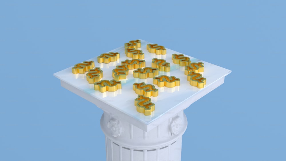 a bunch of gold numerals sitting on top of a white pedestal