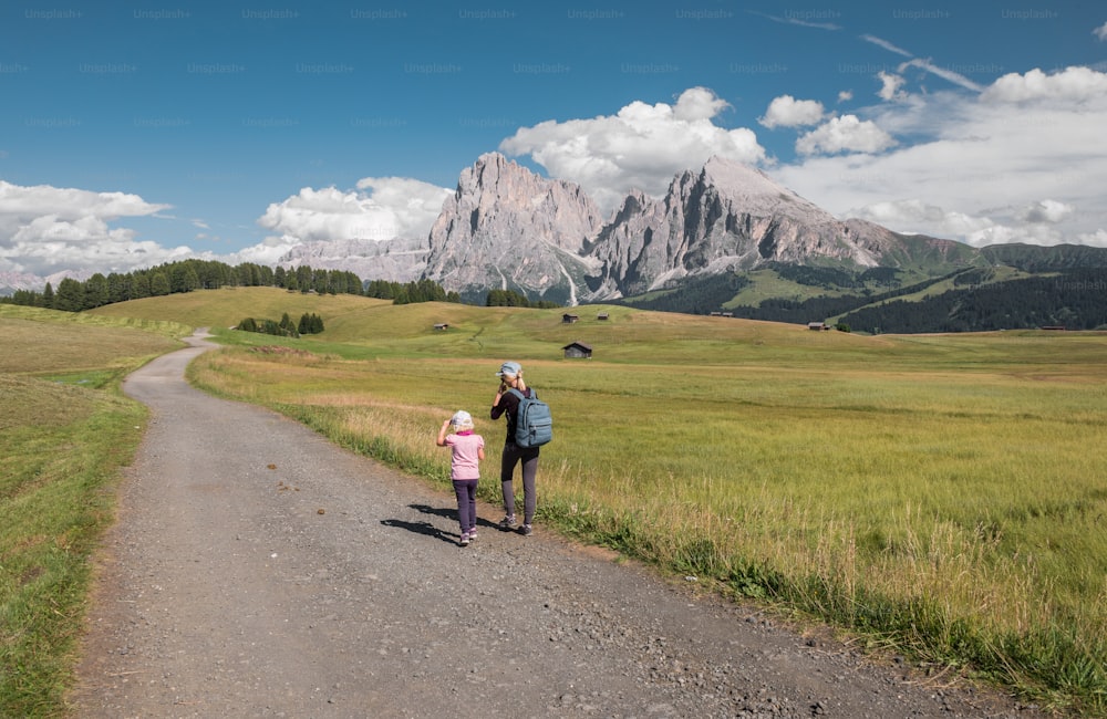 Ein Mann und ein kleines Mädchen gehen einen Feldweg entlang