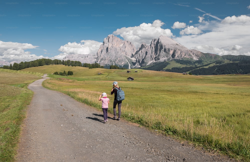 a man and a little girl walking down a dirt road