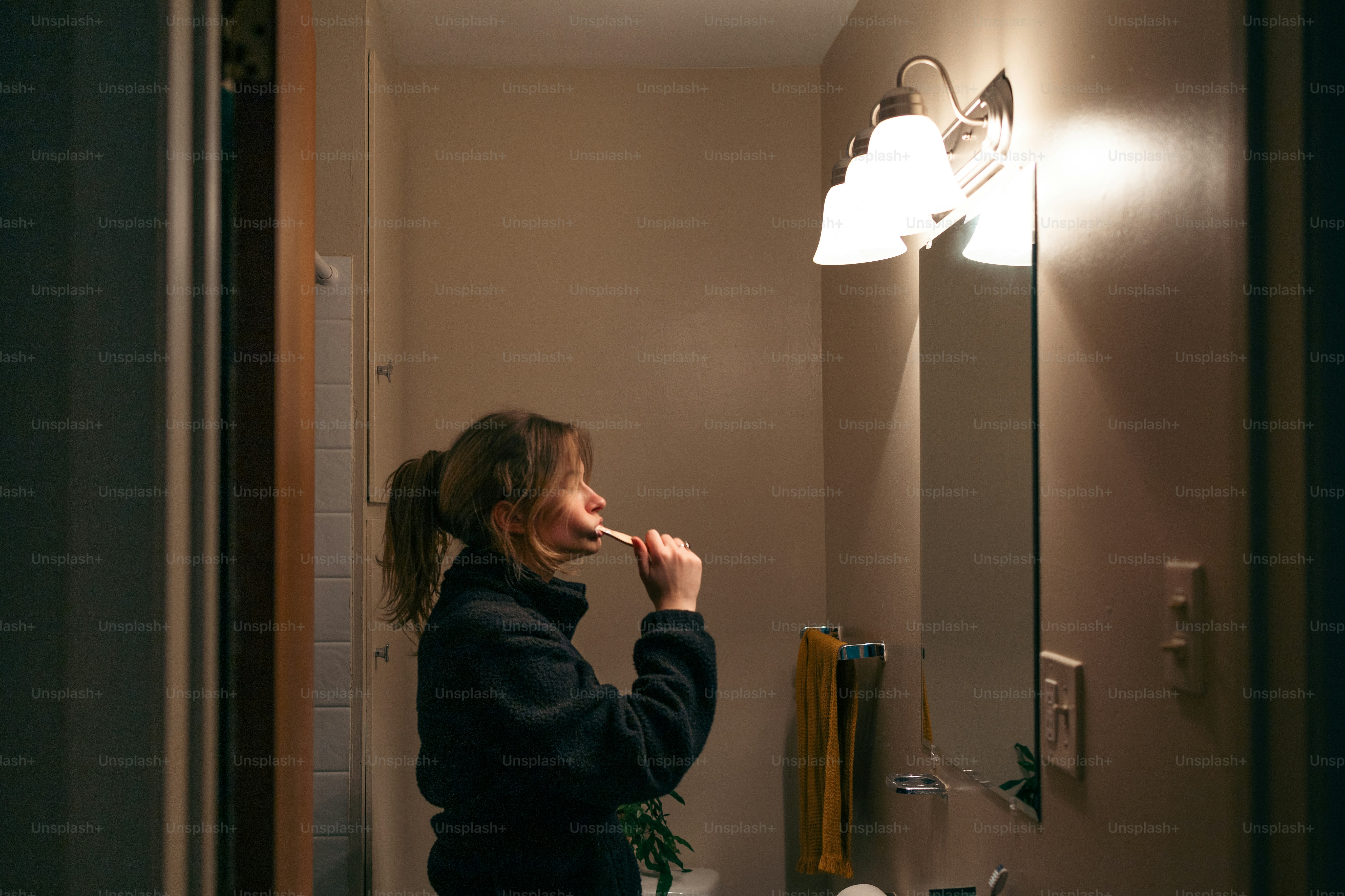 Una donna che si lava i denti in un bagno