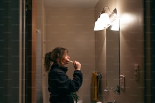 バスルームで歯を磨く女性