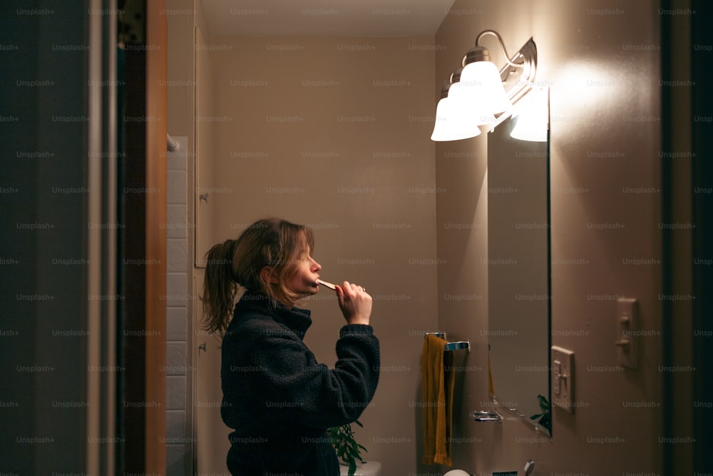 a woman brushing her teeth in a bathroom