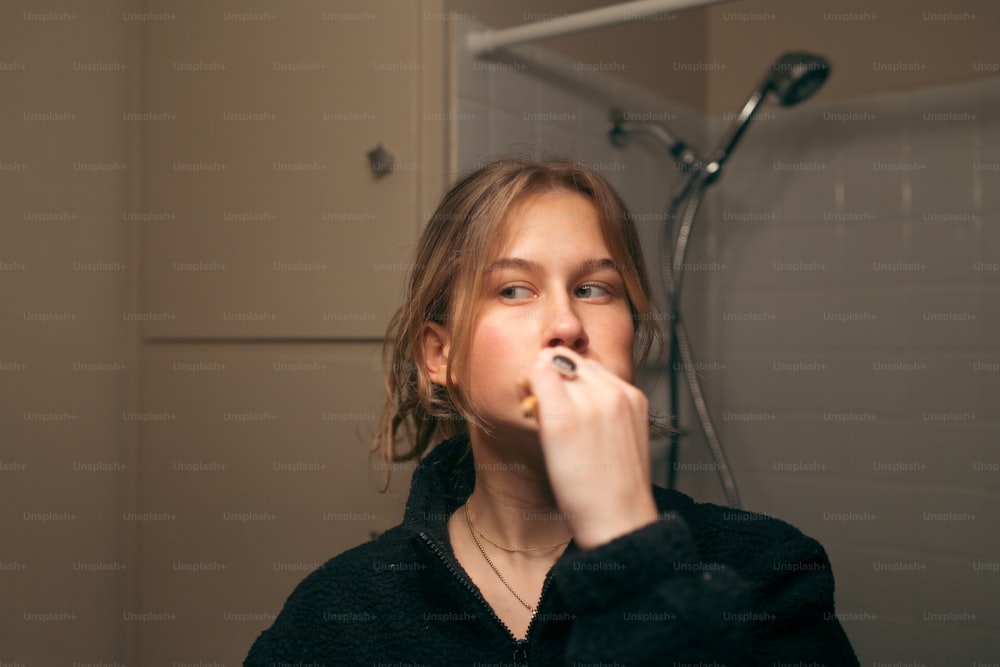 a woman brushing her teeth in a bathroom