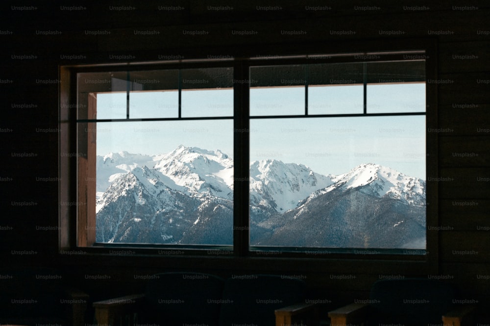a window with a view of a snowy mountain range