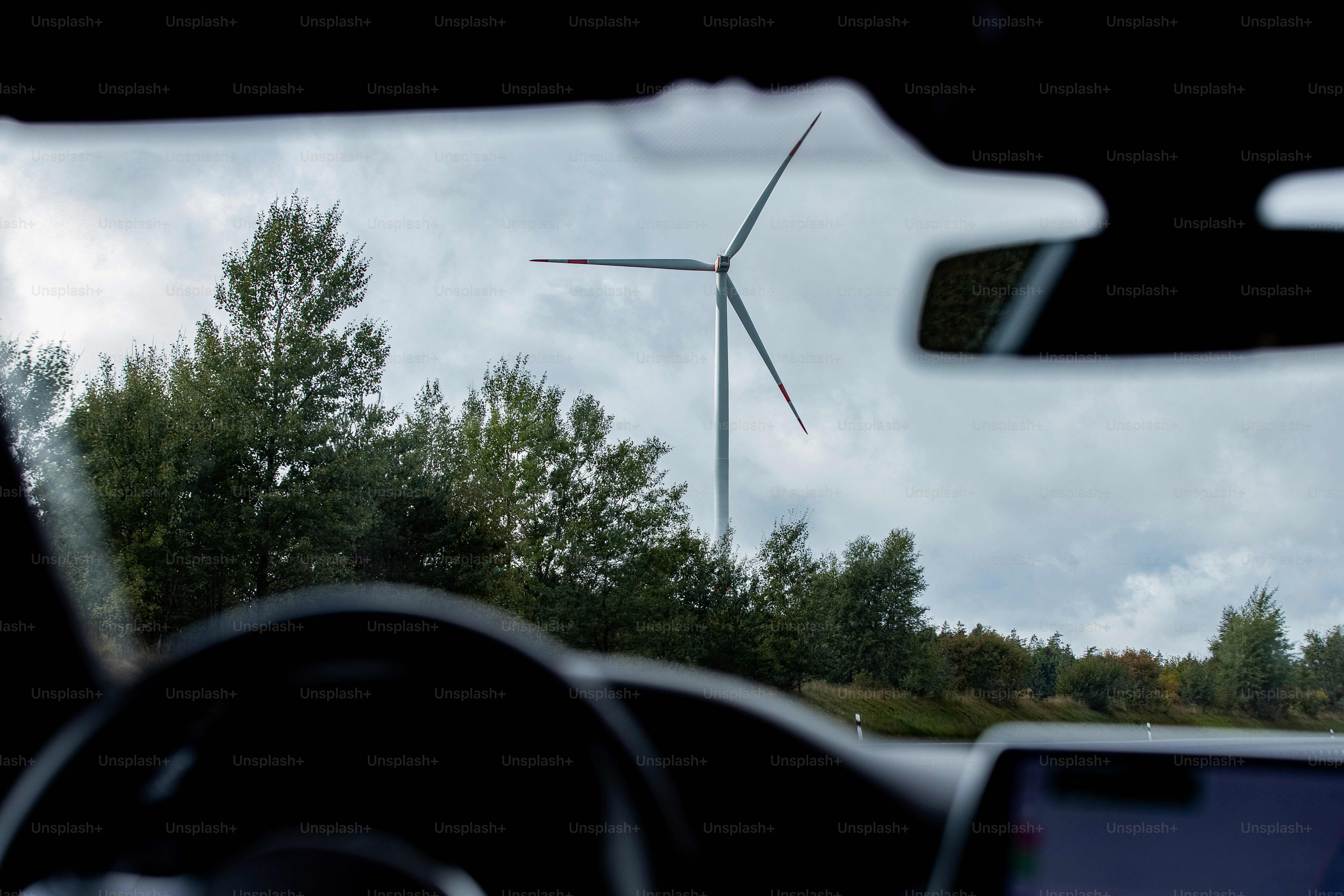 a view of a wind turbine from inside a car