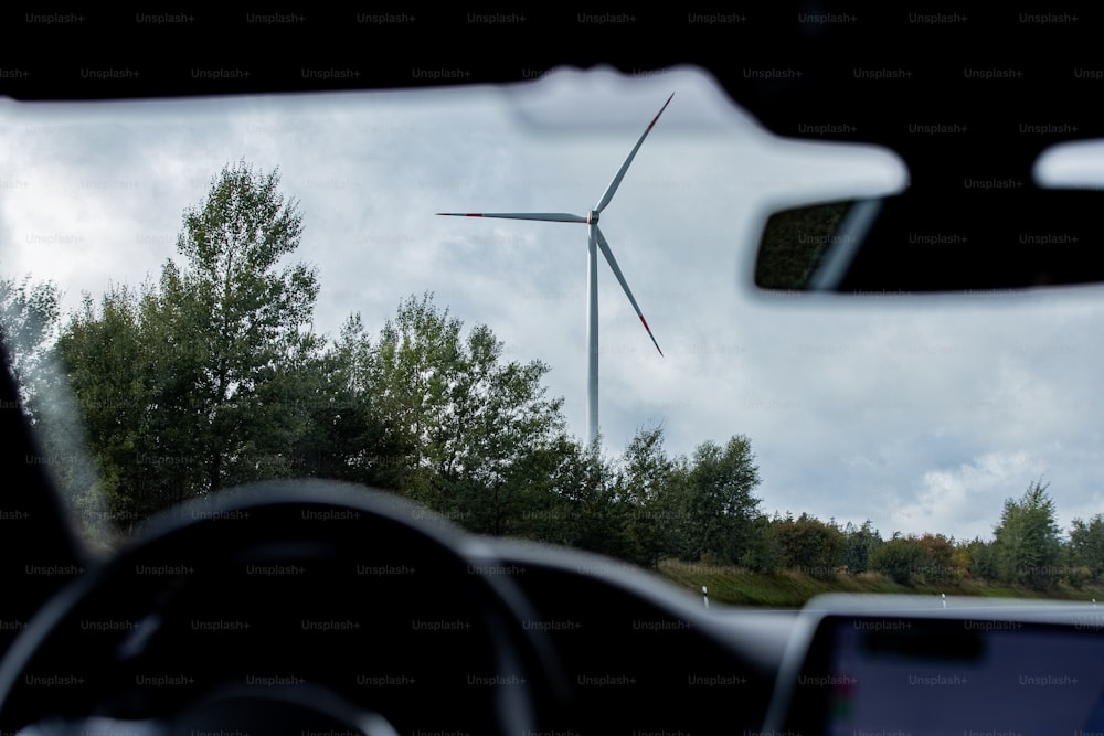 a view of a wind turbine from inside a car