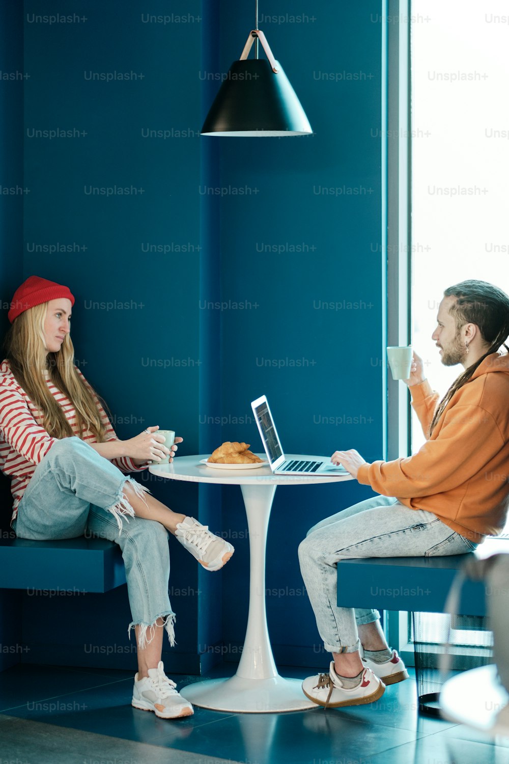 a man and a woman sitting at a table with a laptop