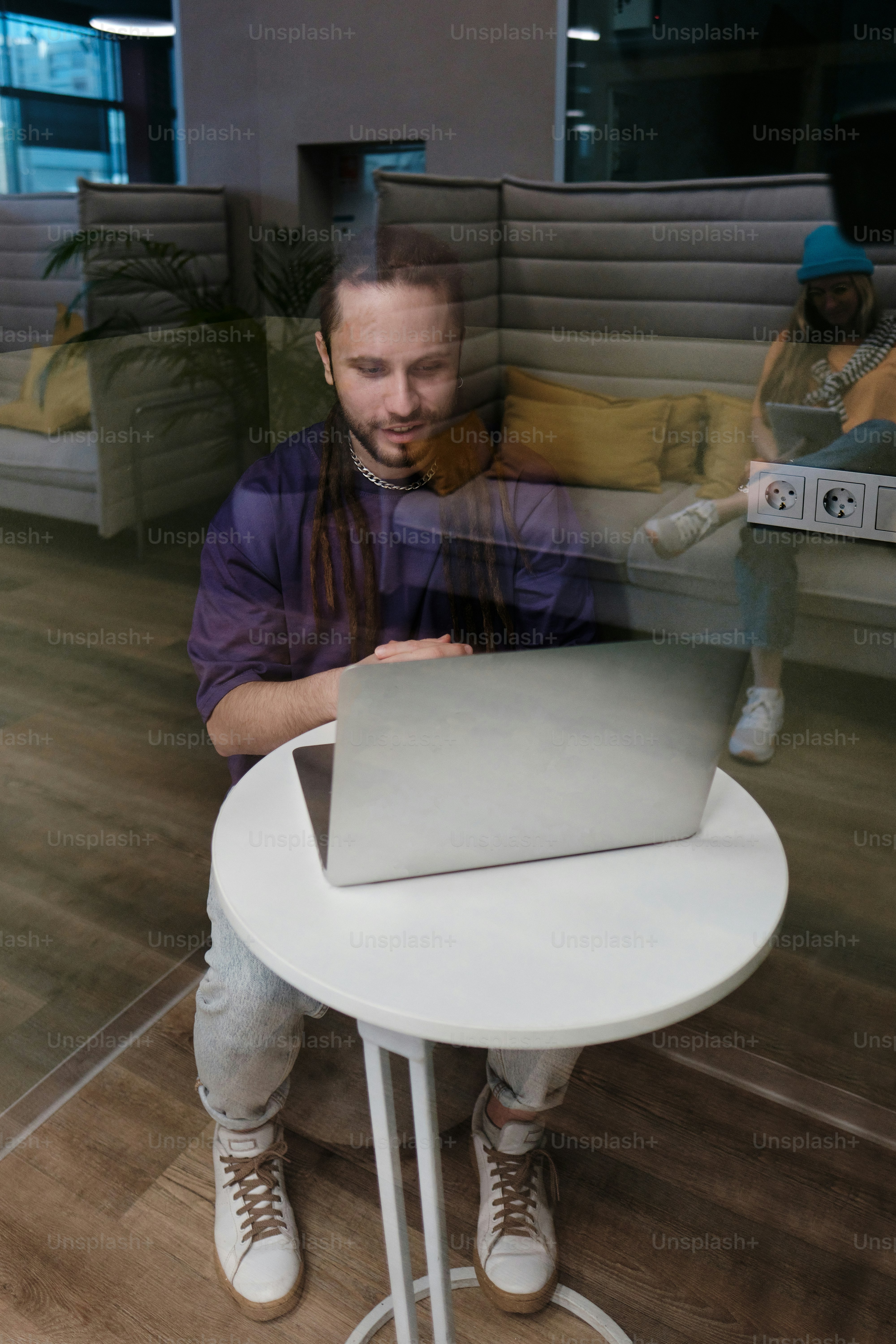 Ein Mann sitzt an einem Tisch mit einem Laptop