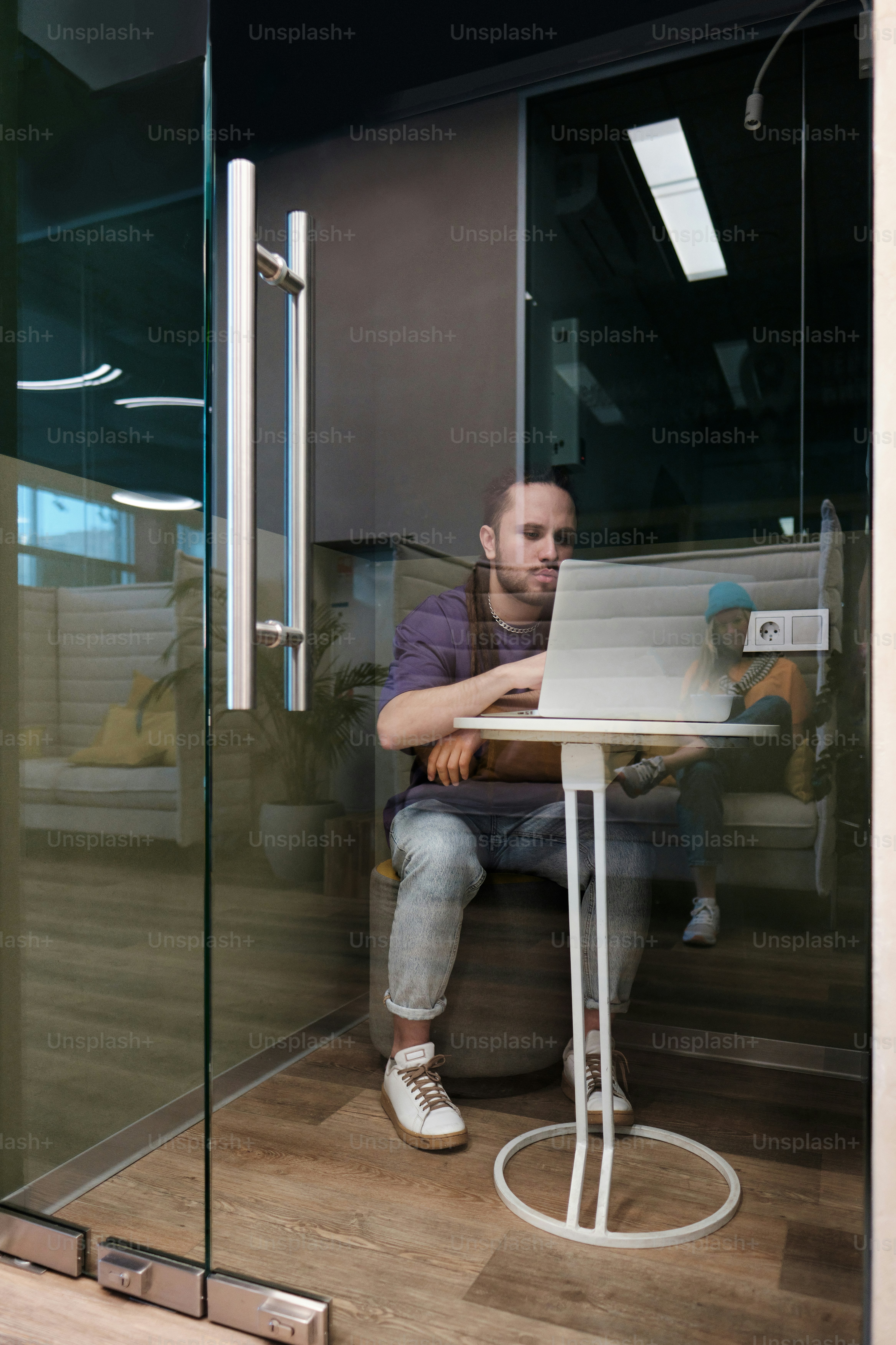 a man sitting at a table using a laptop computer