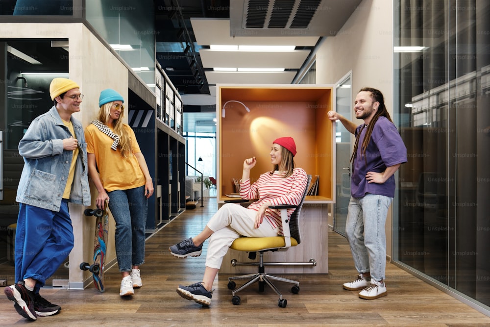 a group of people standing and sitting around a cubicle
