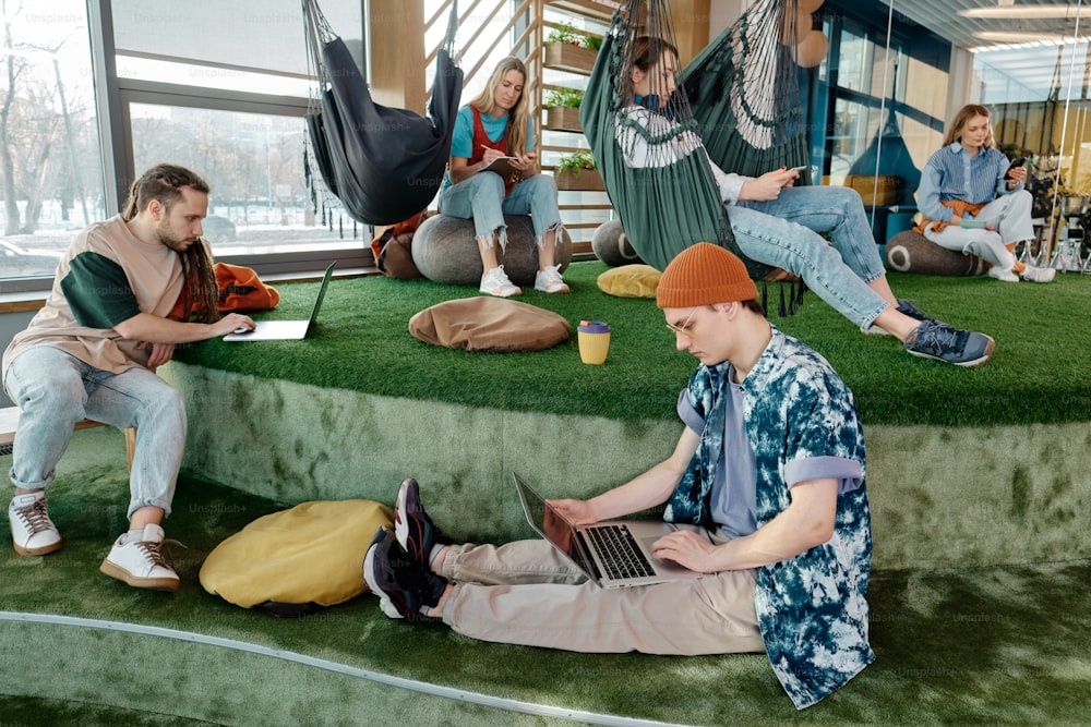 a group of people sitting on top of a lush green field