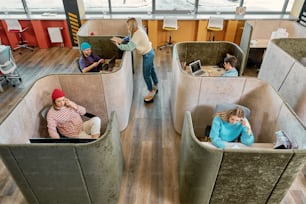 a group of people sitting in cubicles in a building