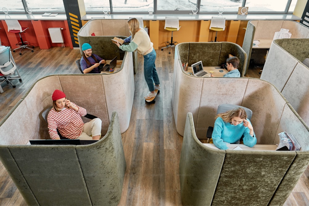 um grupo de pessoas sentadas em cubículos em um prédio