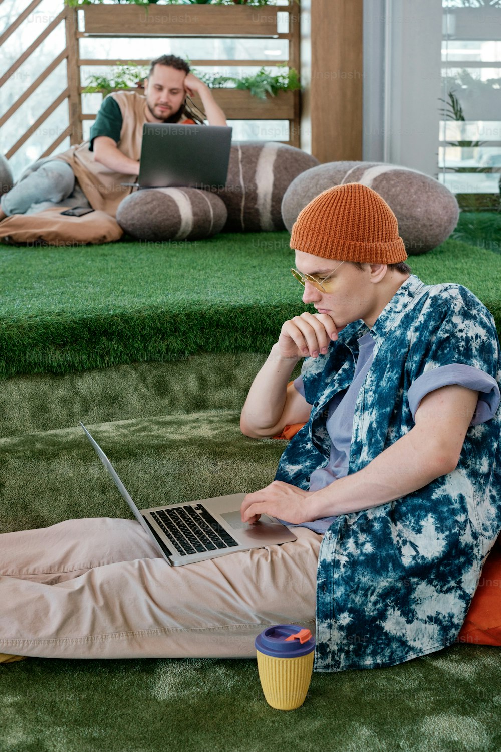 a man sitting on the ground using a laptop