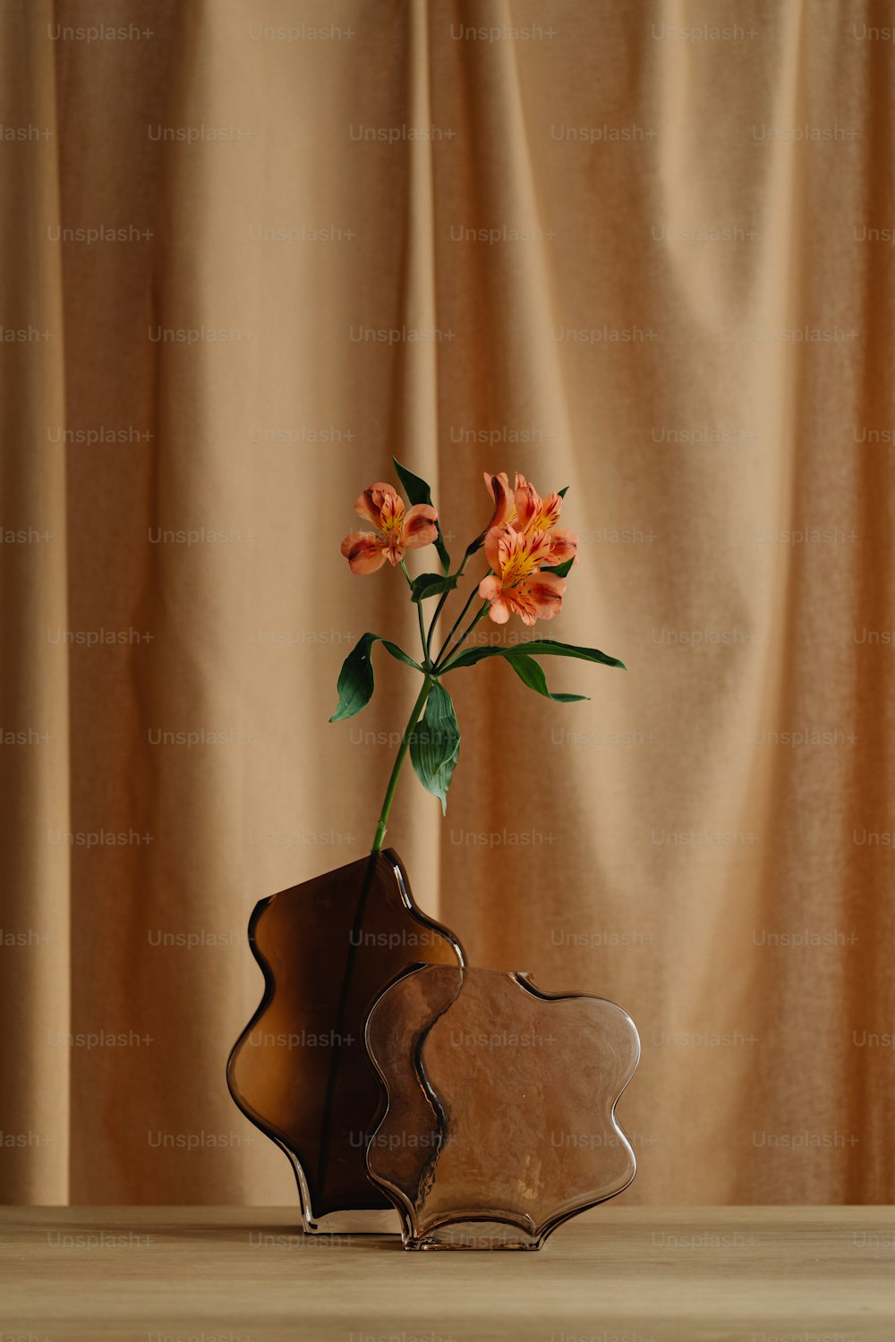 un vase avec des fleurs dedans assis sur une table