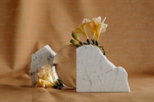 a white marble vase with yellow flowers in it