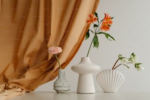 three vases with flowers in them sitting on a table