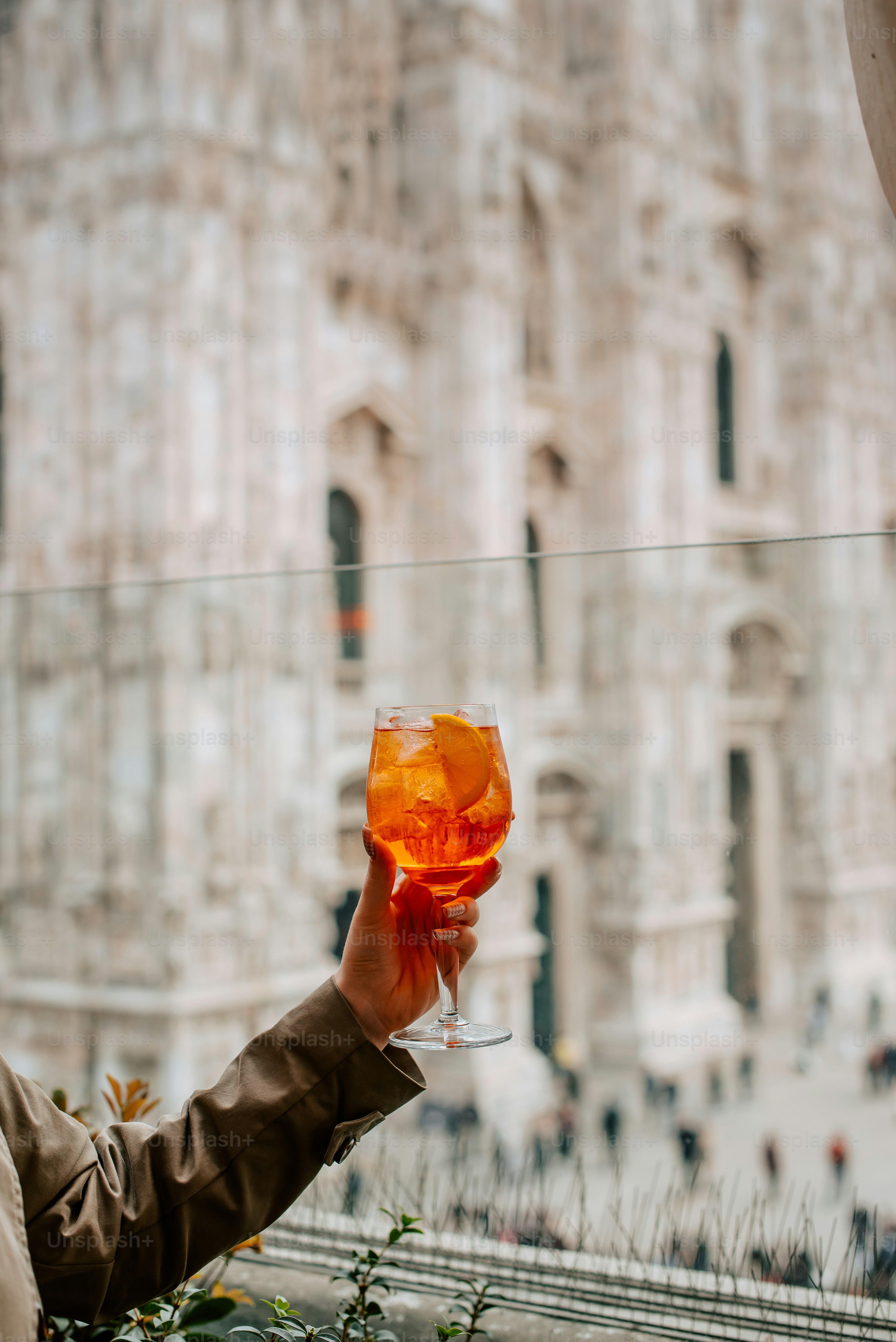 建物の前でワイングラスを持つ人