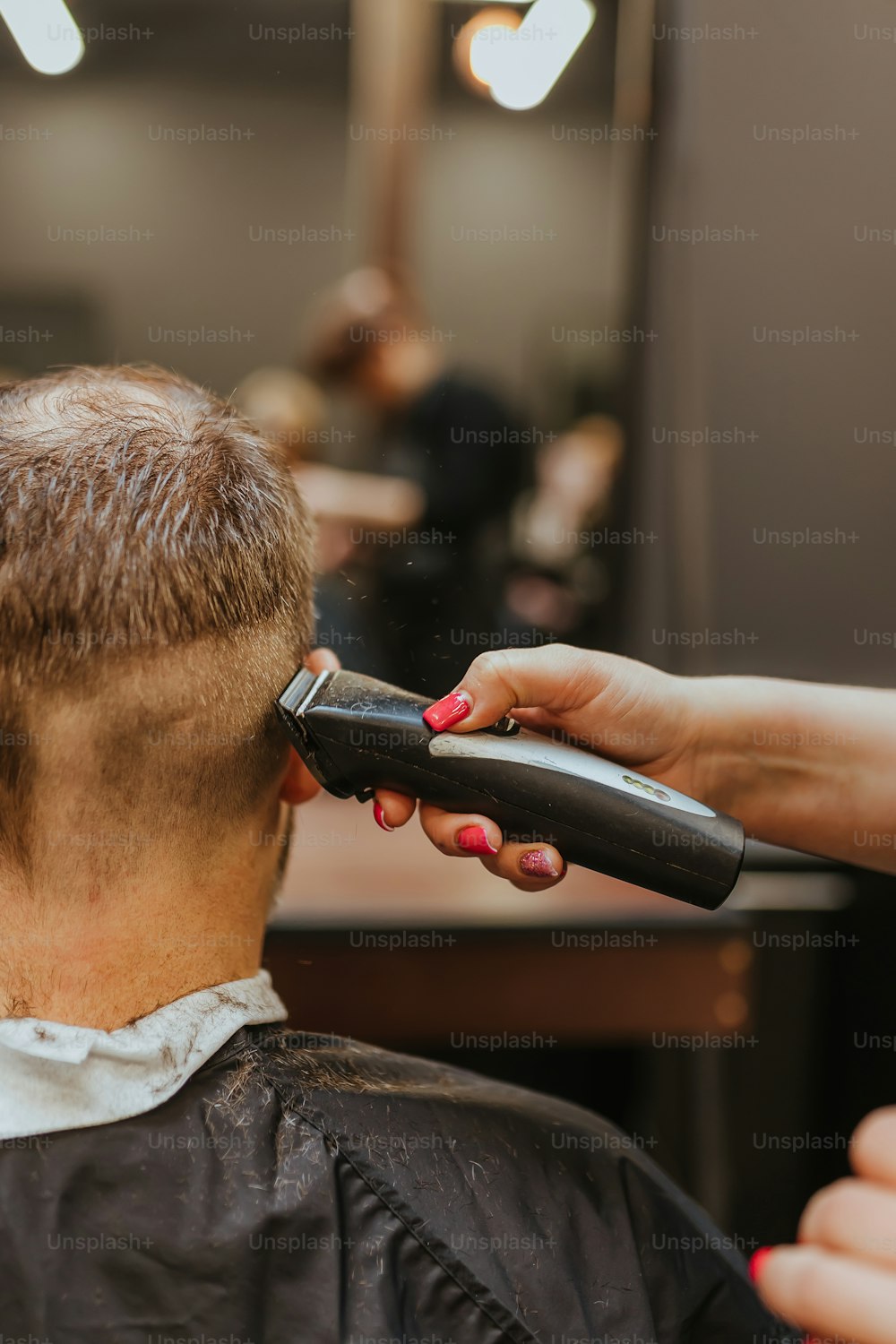 ヘアドライヤーで男性の髪を切る女性