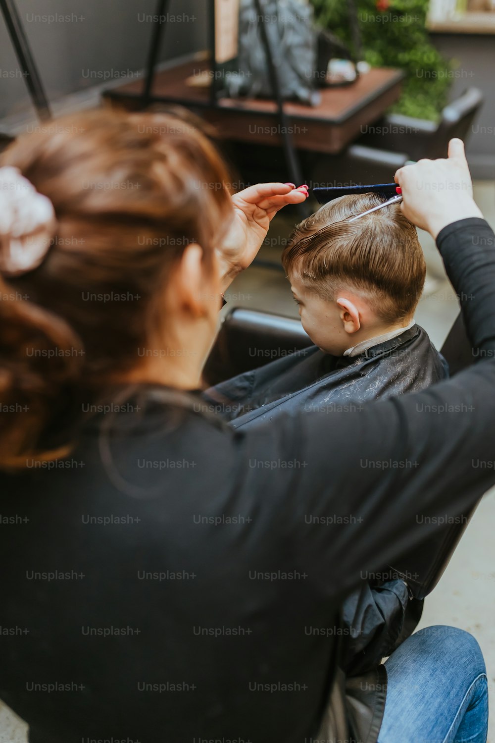 a woman cutting a man's hair with scissors