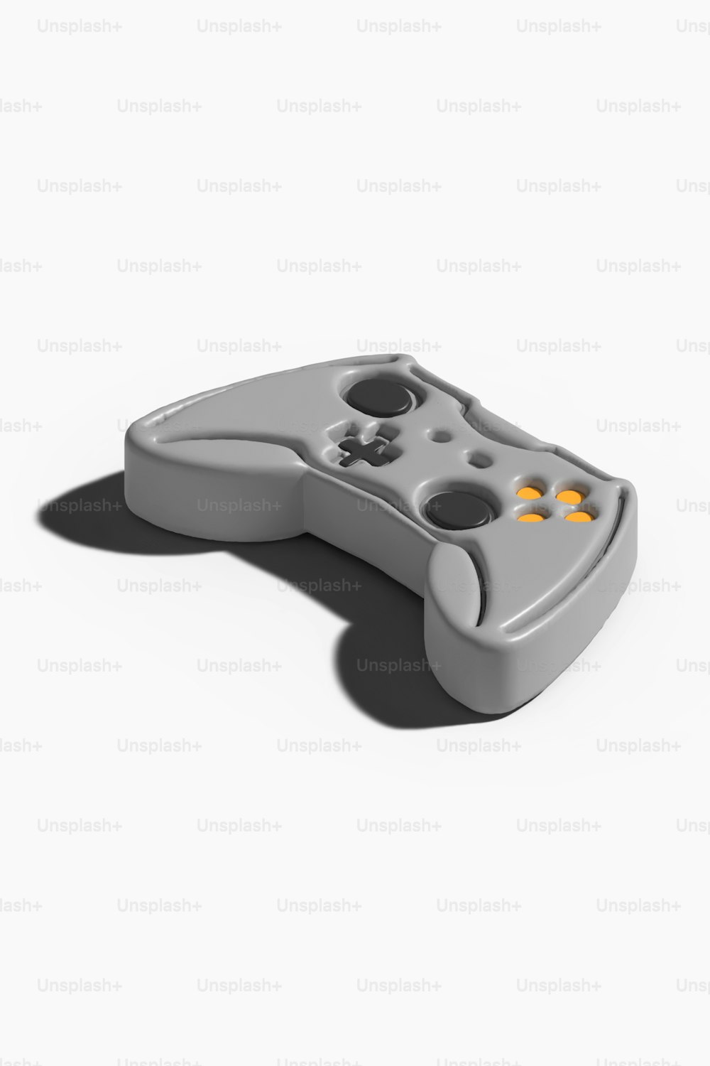 a gray game controller sitting on top of a white surface