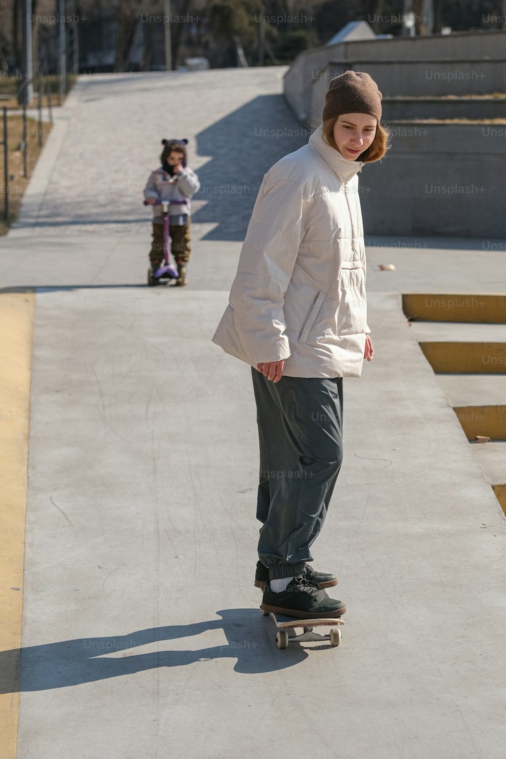 a young man riding a skateboard down a sidewalk