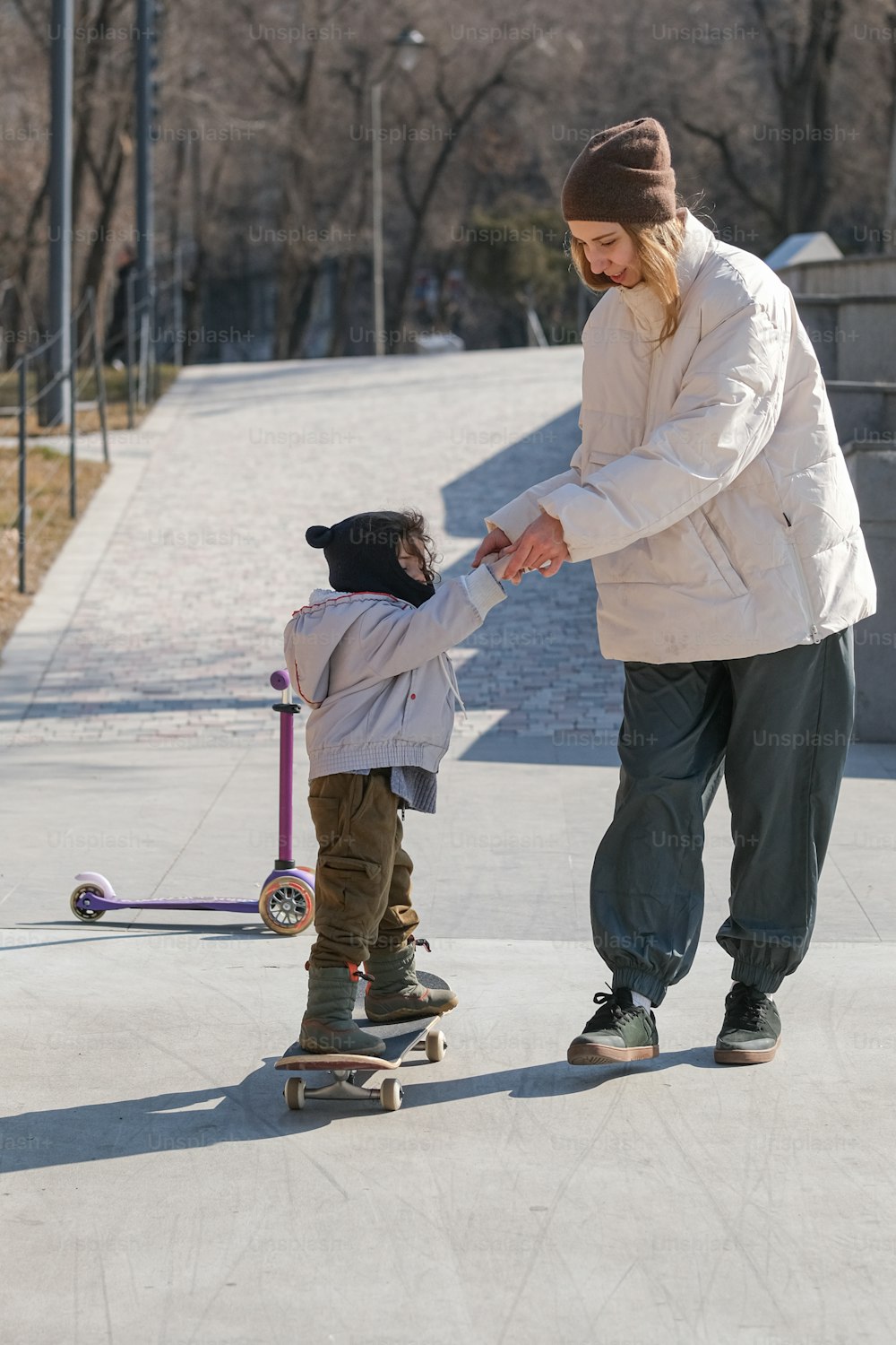 Ein Mann, der einem kleinen Kind das Skateboardfahren beibringt