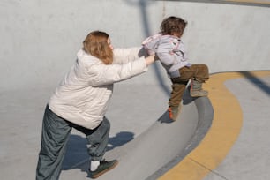 a woman and a child playing on a skateboard ramp