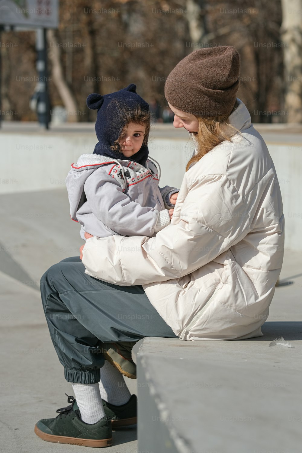 a woman and a child are sitting on a skateboard