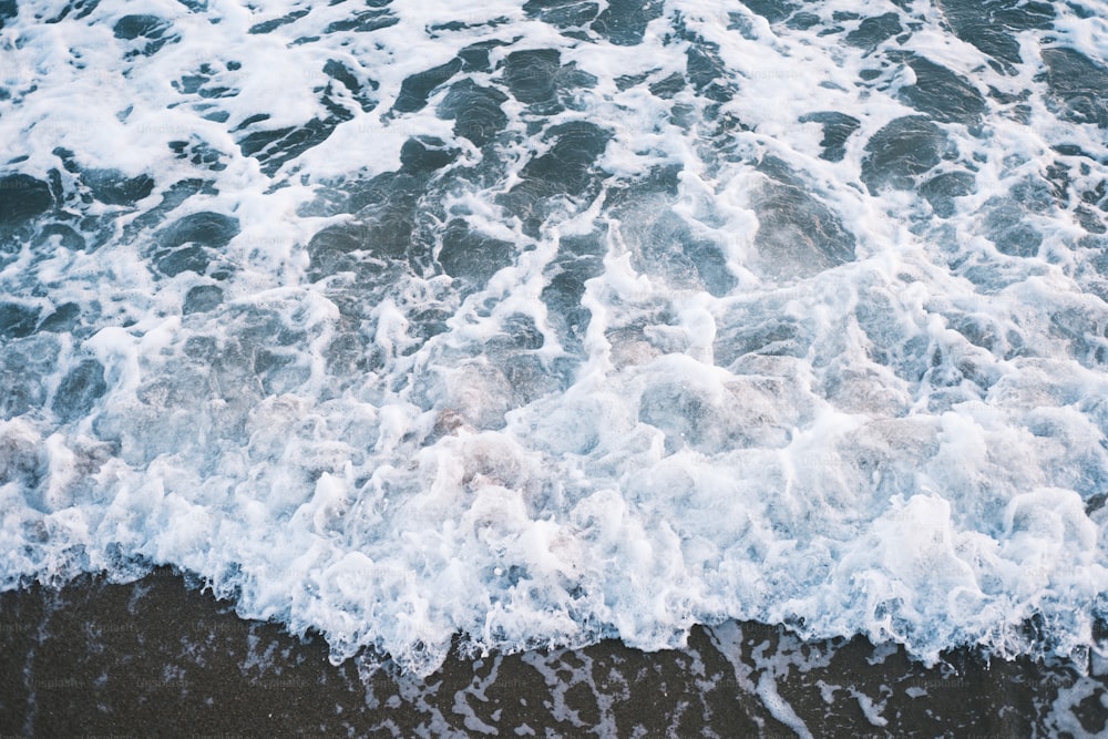 a close up of the ocean waves on a beach