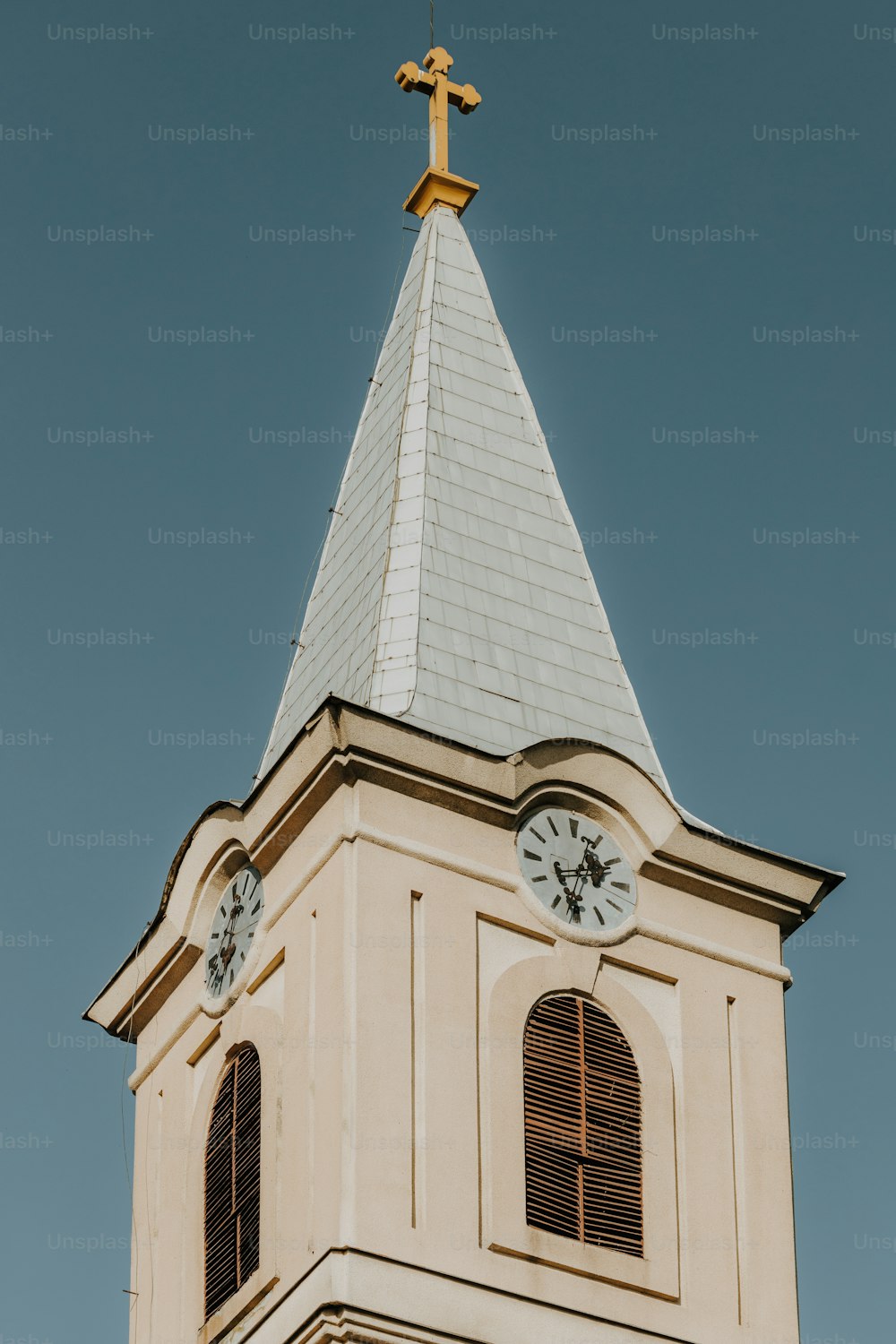 una torre del reloj con una cruz encima