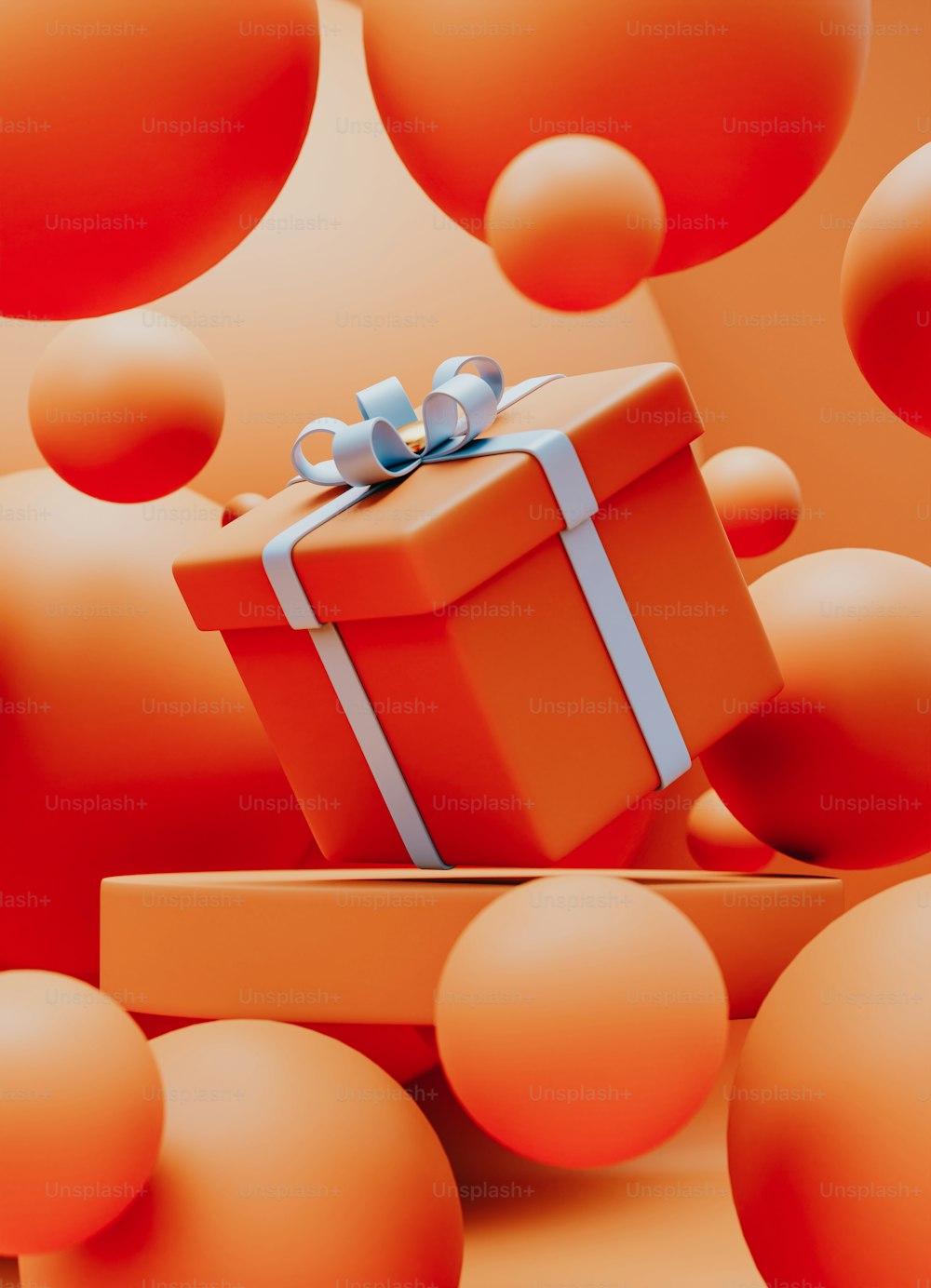 Una scatola regalo con un fiocco è circondata da palline arancioni