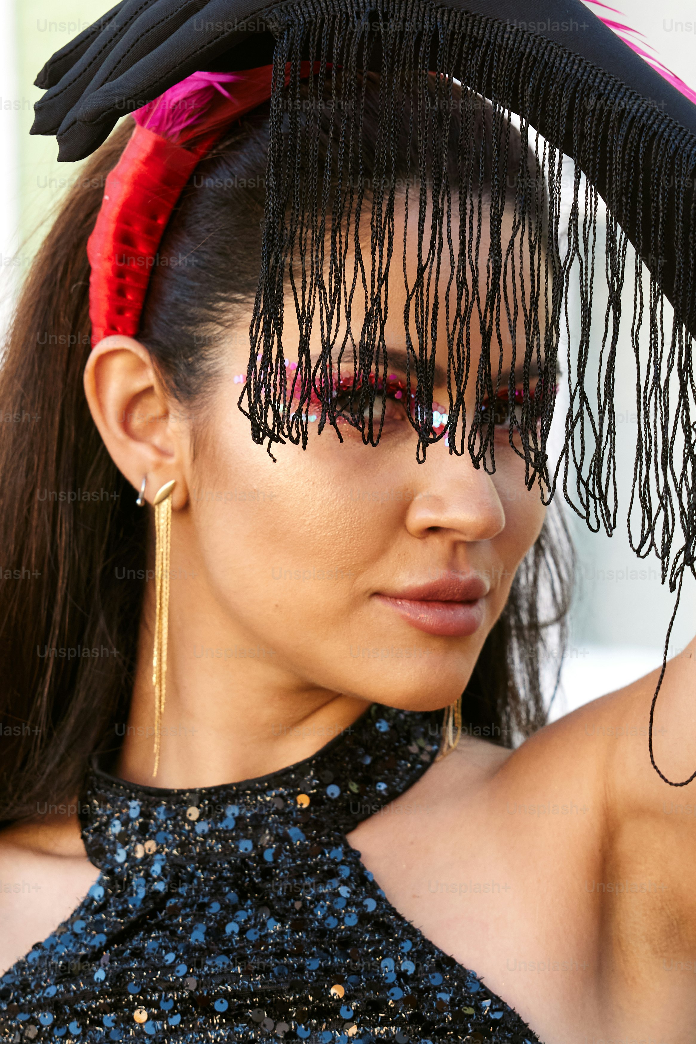 a woman wearing a black dress and a red feathered hat
