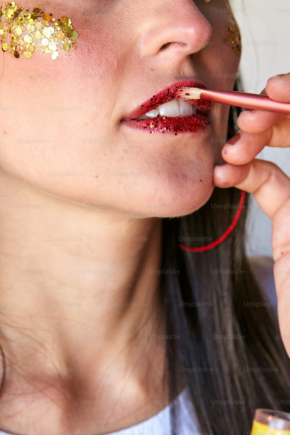 a woman with gold paint on her face and lip