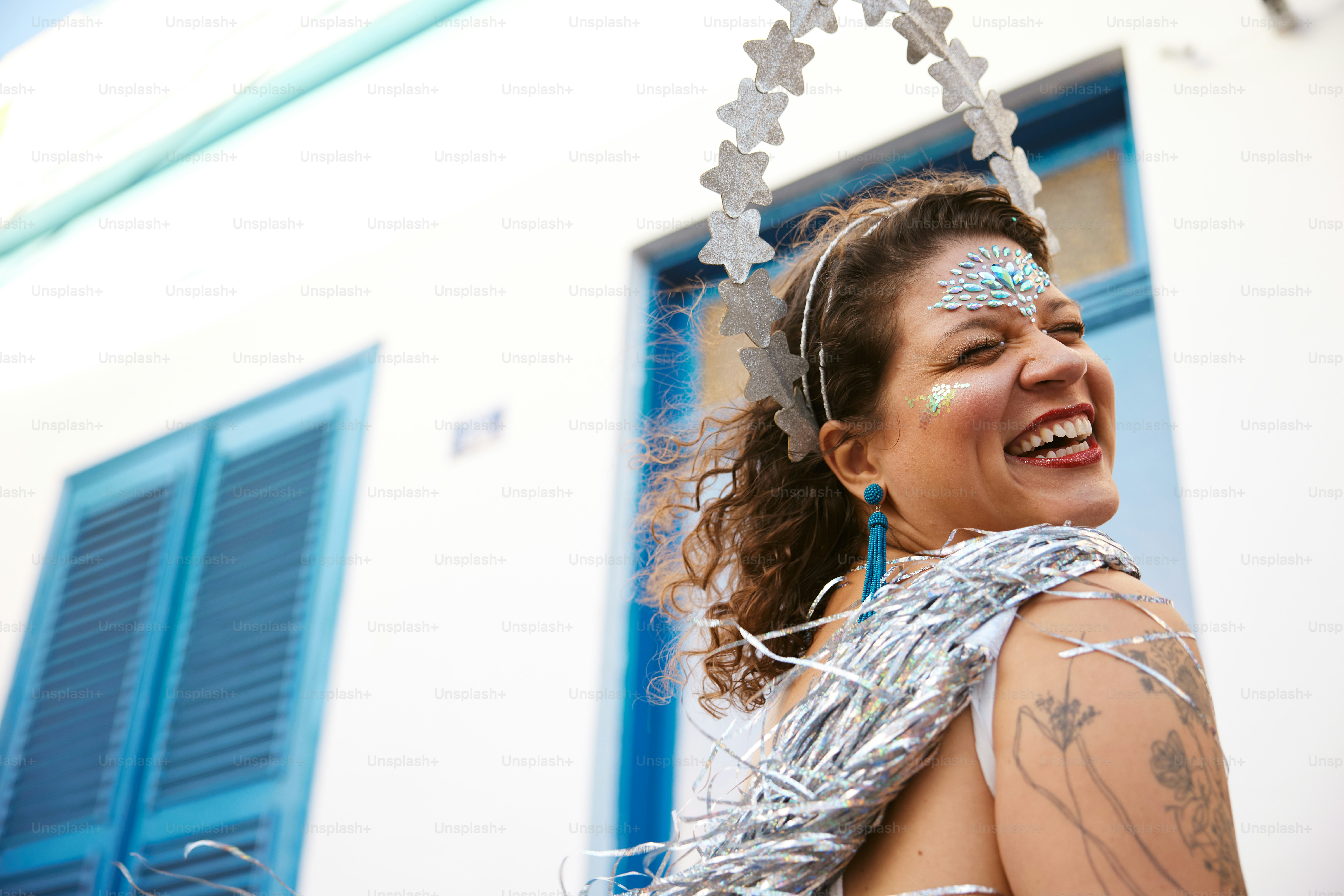a woman wearing a silver dress and a head piece