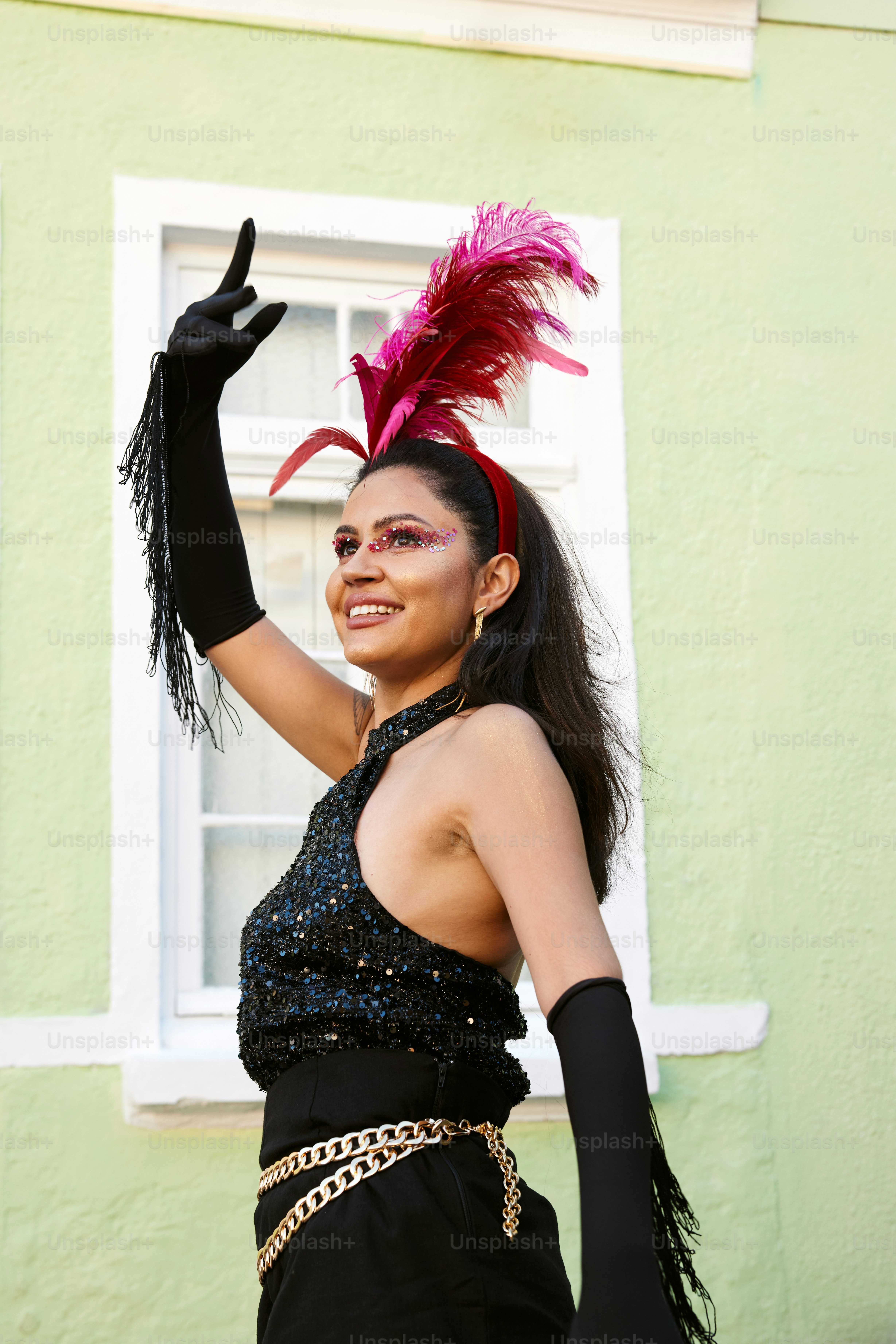 uma mulher vestindo um vestido preto e um chapéu de penas cor-de-rosa